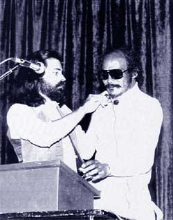 Paul Fericano adjusting mike for Bob Kaufman at the Street Poetry Reading at U.C. Extention Center.  1978.  Copyright A.D. Winans.